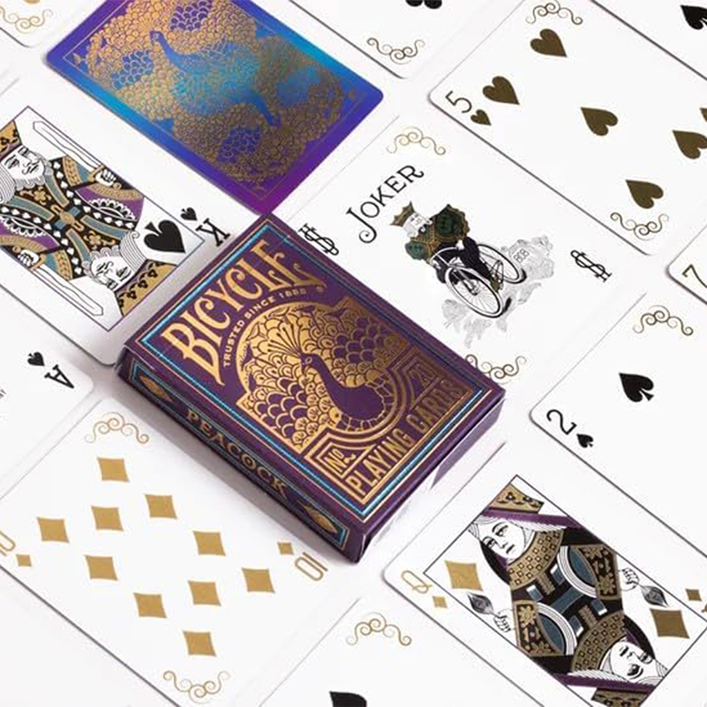 purple box of playing cards next to gold and purple themed cards