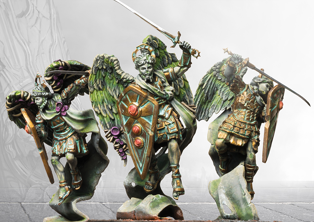 three painted miniatures of stone angels with swords and shields